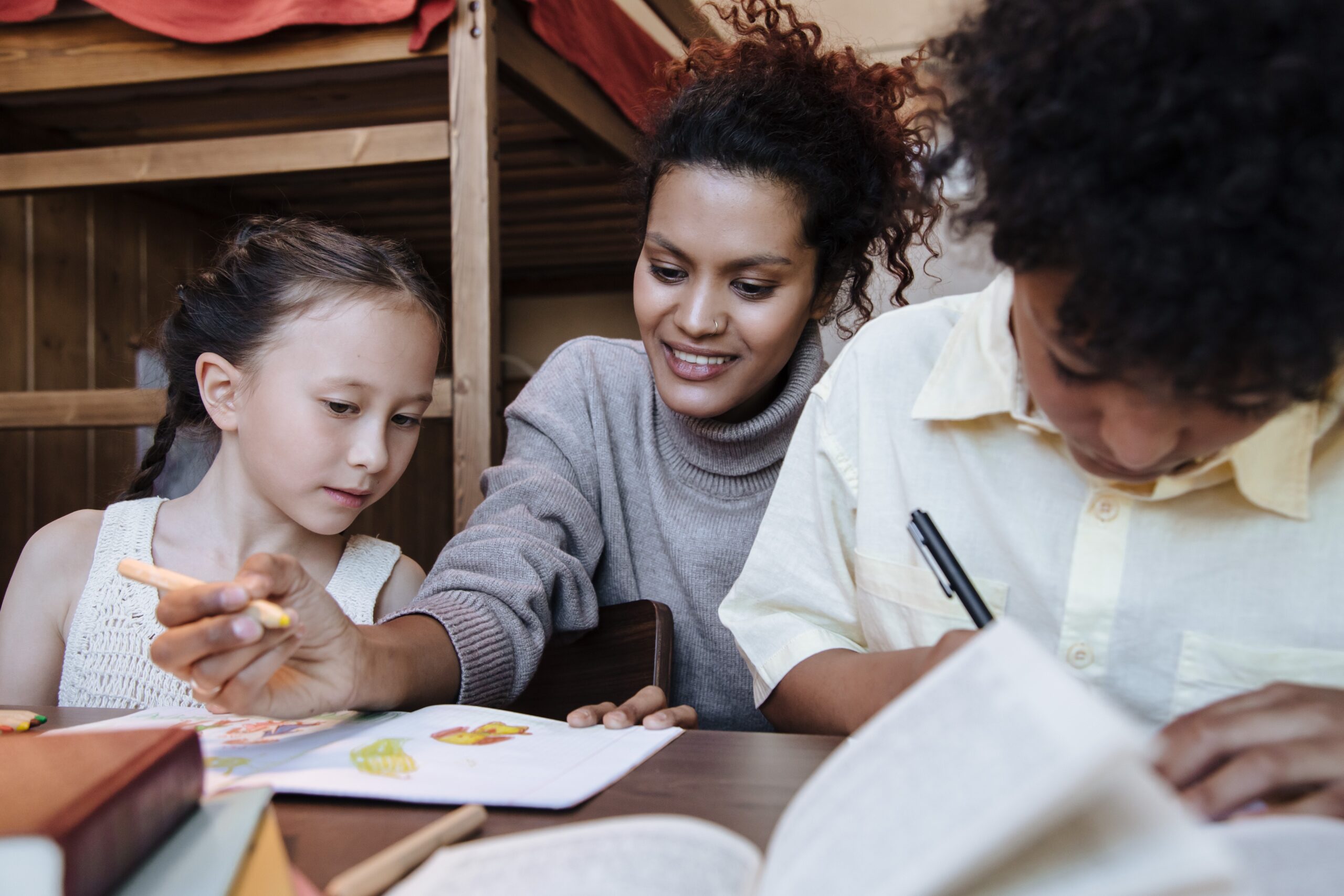 A woman helping children with their homework